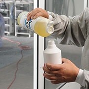 Man die vloeibare zeep en water mengt in een spuitfles