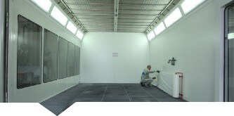  Man die 3M Dirt Trap beschermingsmateriaal aanbrengt op de wanden van een spuitcabine
