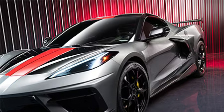 Hero-foto van een grijze coupé met een rode motorkapwrap.
