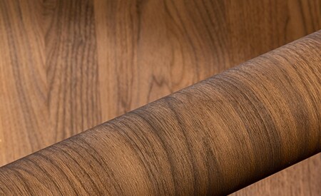 Rol DINOC-folie met houtnerf op houten ondergrond
