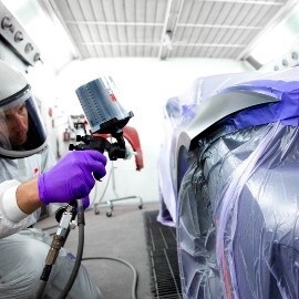 Spuiter die een deel van een auto spuit met een hoogwaardig spuitpistool van 3M