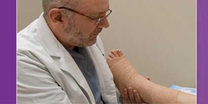 Zorgverlener die compressietherapie bij een patiënt aanbrengt
