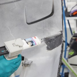 Een handpistool gebruiken om flexibel reparatiemateriaal op de achterkant van de barst aan te brengen