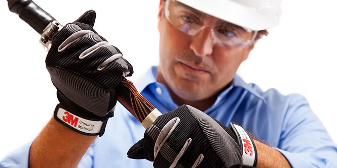 Werknemer in veiligheidsuitrusting inspecteert elektrische kabel
