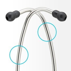 Glimmend aluminium oorbuizen van een 3M Littmann Stethoscoop kruisen elkaar symmetrisch met zwarte oordopjes op de uiteindes. 