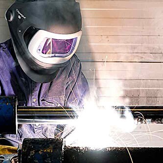 Vonken vliegen rond in een fabriek wanneer een technicus metalen ondergronden aan elkaar last