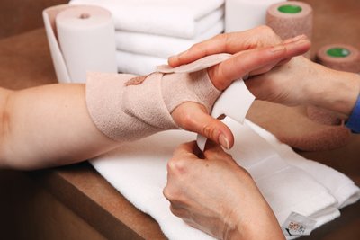 Zorgverlener die compressietherapie bij een patiënt aanbrengt
