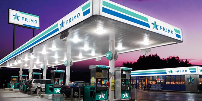 Benzinestation met levendige blauwe en groene graphics en bord met achtergrondverlichting
