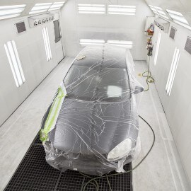 Een auto in een spuitcabine tijdens het geforceerde droogproces