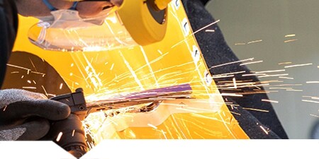  Technicus die een metalen carrosseriedeel snijdt.
