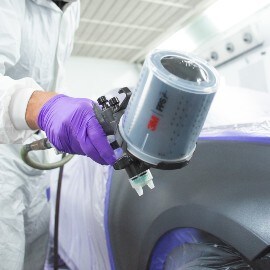 Man die een auto spuit met behulp van het 3M PPS serie 2.0 performance spuitpistool