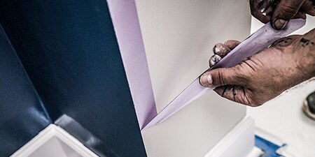 Professionele schilder die na gebruik 3M Maskeertape verwijdert
