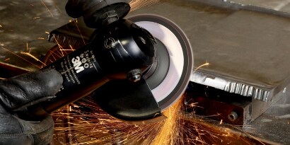 Een metalen rand wordt afgeschuind met een lamellenschijf
