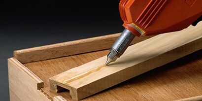 Vloeibare lijm die op hout wordt aangebracht
