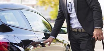 Man die een auto opent 
