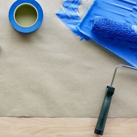ScotchBlue™ Afplaktape naast een kwast bedekt met blauwe verf