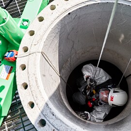 Een werknemer die een helm van 3M draagt in een besloten ruimte