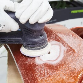 Het carrosserieoppervlak schuren met een schuurschijf