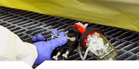 Technicus die 3M Accuspray Gun gebruikt om beschermende coating aan te brengen
