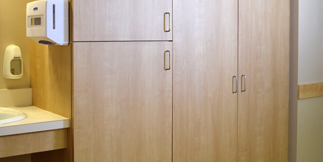 Afbeelding van de gootsteen en opbergkast in de kamer in het ziekenhuis die werden opgeknapt met een lichte houtkleurige 3M DI-NOC architectuurfolie
