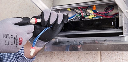 Een man zet een elektrische kabel vast met 3M tape.
