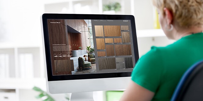 Afbeelding van een vrouw die een desktopcomputer gebruikt om door de interactieve catalogus te bladeren.

