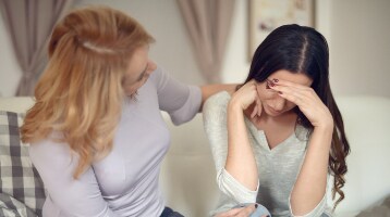 Afbeelding van een gespannen patiënt die in gesprek is met een familielid
