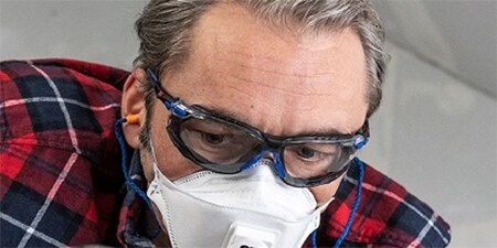  Een man die 3M oogbescherming draagt tijdens het klussen
