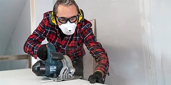 Een man die persoonlijke beschermingsmiddelen van 3M Veiligheid draagt tijdens het klussen
